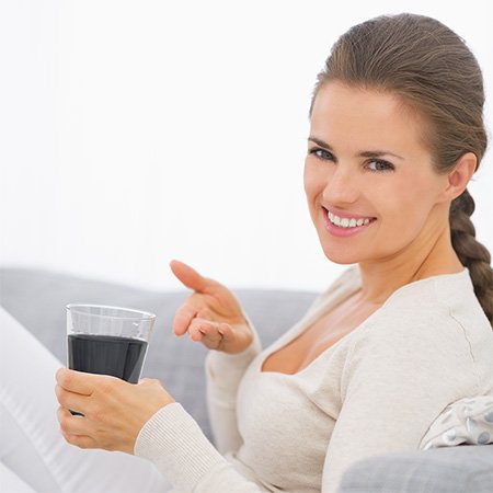 Mujer tomando agua con carbón activado