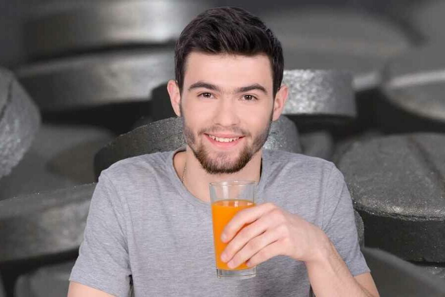 hombre tomando pastillas de carbón activado con jugo